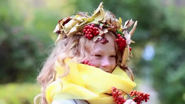 Alegre chica feliz con una corona en su cabeza ceniza de montaña en el bosque de otoño — Vídeos de Stock