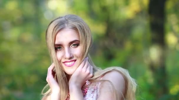 Лицо красивой блондинки с длинными волосами на природе осенний день — стоковое видео
