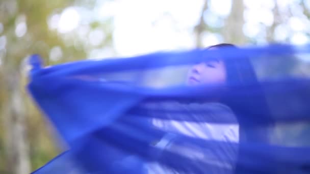 Menina bonita com um pano azul na floresta — Vídeo de Stock