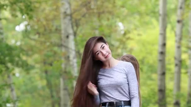 Duas menina bonita com cabelos longos no parque de verão — Vídeo de Stock