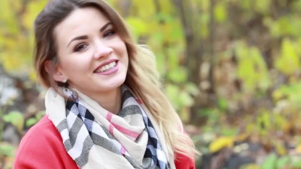 Όμορφη νεαρή γυναίκα με κόκκινο παλτό στο πάρκο φθινόπωρο — Αρχείο Βίντεο