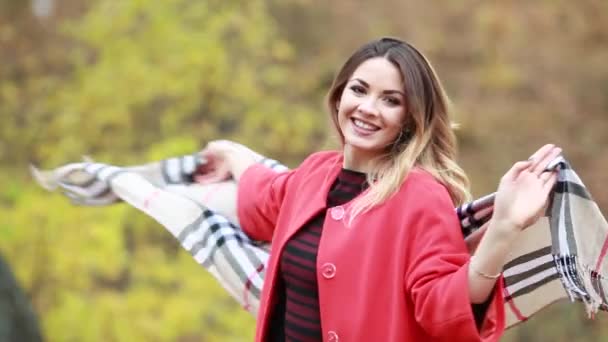 Happy joyful woman in the autumn on the nature swirls in red coat. — Stock Video