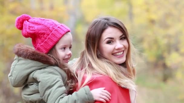 Happy mother and daughter having fun playing on the walk in autumn day — Stock Video