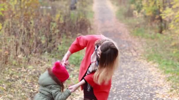 Šťastný matka a dcera baví hrát v parku na podzim — Stock video