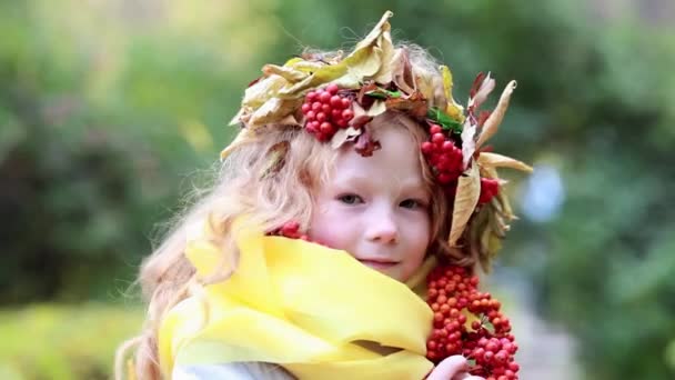 Счастливая девушка с осенними листьями и рябью на голове в осеннем лесу — стоковое видео