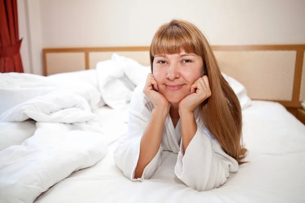 Young woman lying on the bed in the morning — Stock Photo, Image