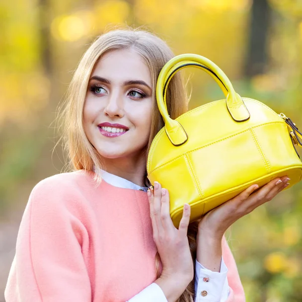 Menina bonita com um saco de couro no outono sobre a natureza — Fotografia de Stock