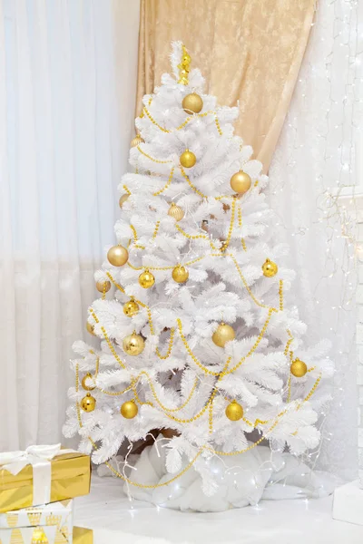 Joyful studio shot of a Christmas tree with colorful ornaments in the interior — Stock Photo, Image