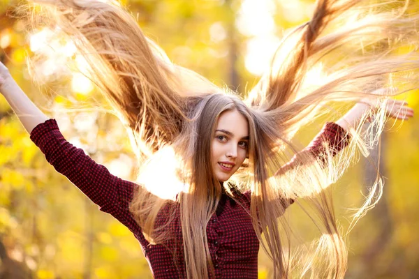 Chica con el pelo largo y hermoso en un bosque en otoño — Foto de Stock