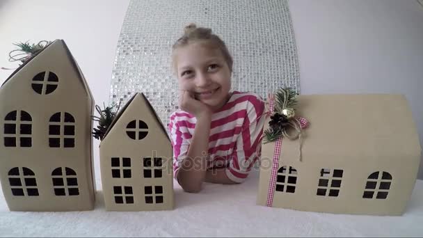 Menina doce com casas de papelão no quarto — Vídeo de Stock