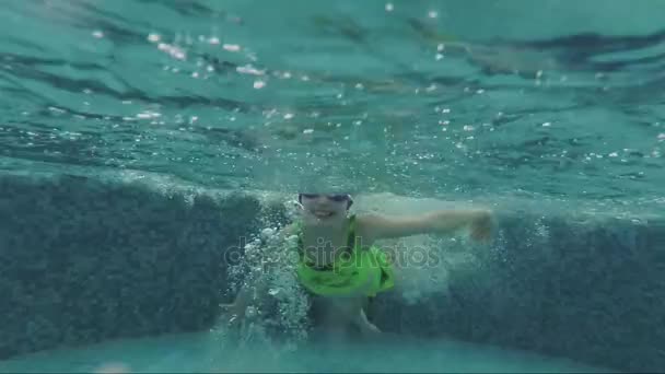 Klein meisje zwemmen onder water in het zwembad — Stockvideo