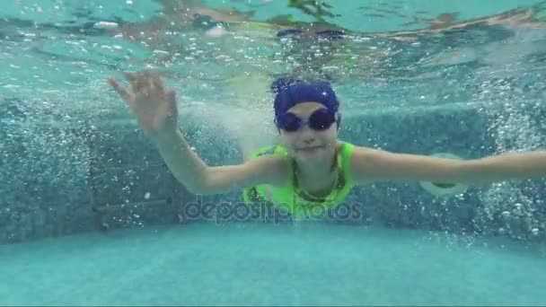 Chica bonita se sumerge en el agua en la piscina — Vídeos de Stock