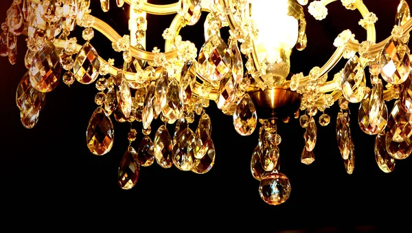 Vacker elegant gyllene ljuskrona i svart tak — Stockfoto