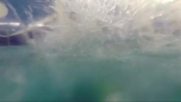 Дівчина в сонцезахисних окулярах під водою під водою в басейні — стокове відео