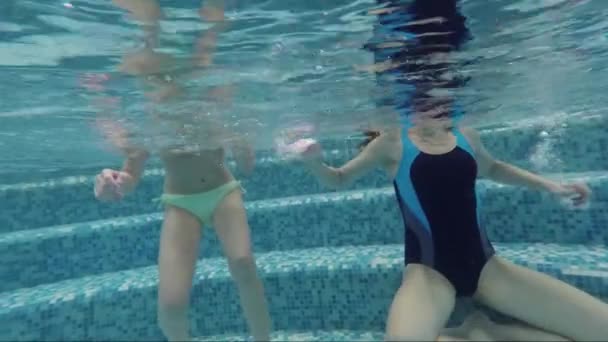 Eine junge Frau und ein halbwüchsiger Junge schwimmen im Pool. Tauchen — Stockvideo