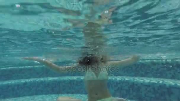 Jeune fille adolescente sous l'eau dans la piscine en position lotus — Video