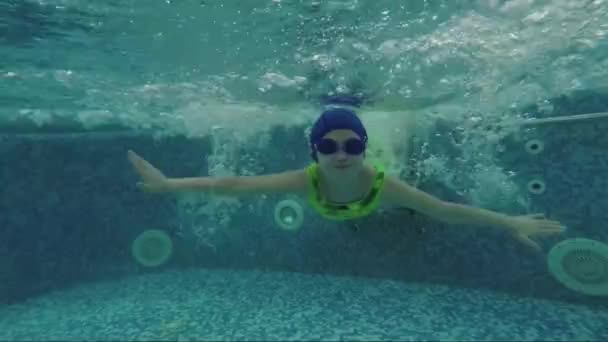 Niño nada en la piscina bajo el agua — Vídeos de Stock