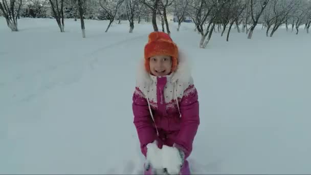 Dítě při chůzi na zimu hází sněhovou zábavu — Stock video