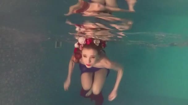 Weibliches glückliches Mädchen schwimmt unter Wasser im Pool — Stockvideo