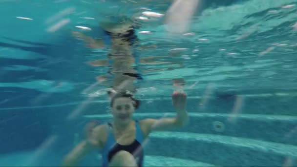 Hermosa chica nadando bajo el agua en la piscina — Vídeos de Stock