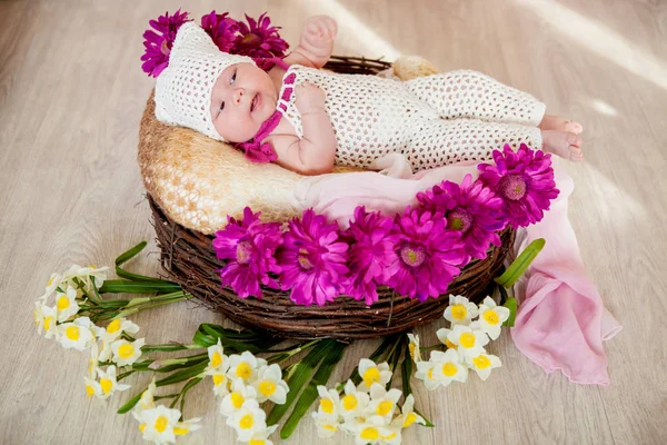 Two-month baby girl in a basket with flowers — Stock Photo, Image