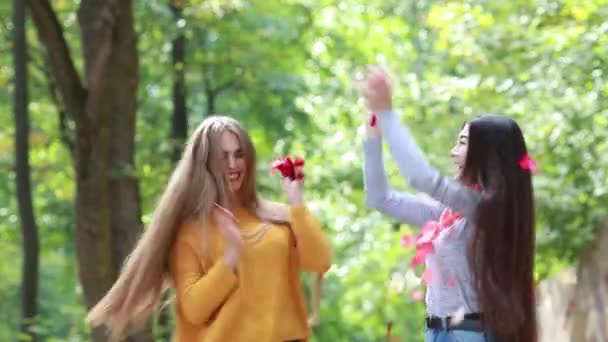 Gül yaprakları atan iki genç kız — Stok video