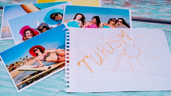 Fotografie krásných dívek na pláži a pas na dřevěný stůl a kousek papíru s plátnem — Stock fotografie