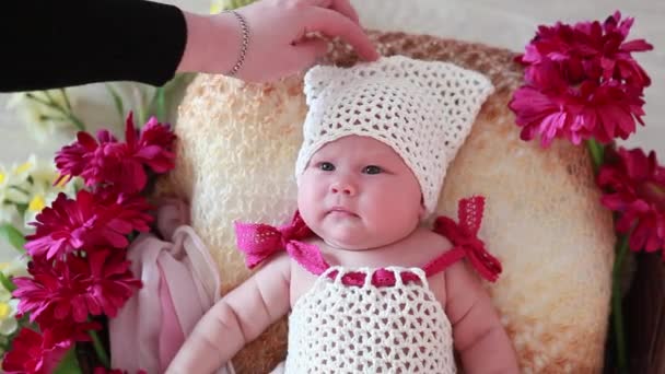 Bebê em um boné branco em flores — Vídeo de Stock