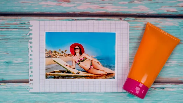 Ahşap masa ve plaj ve güneş koruyucu bir kız fotoğraf — Stok fotoğraf