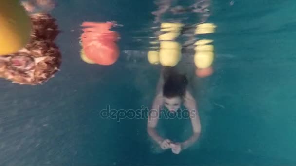 Подводная фотография девушки и фруктов — стоковое видео