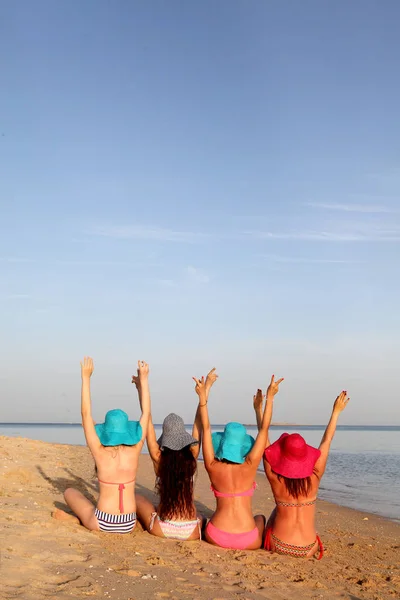 Ett företag av unga kvinnor vilar på havsstranden — Stockfoto