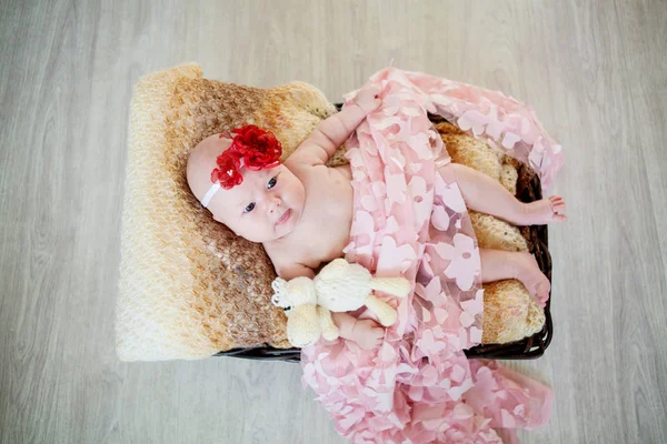 Vacker liten två-månader gammal flicka i en korg — Stockfoto