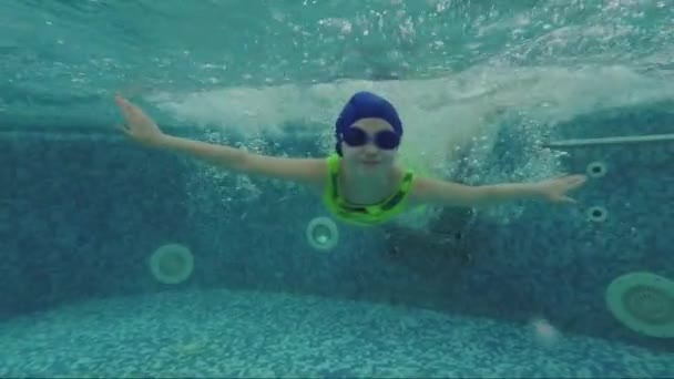 Criança alegre nada na piscina debaixo de água. Movimento lento — Vídeo de Stock