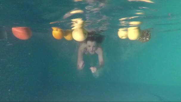 Молодая женщина с фруктами под водой — стоковое видео