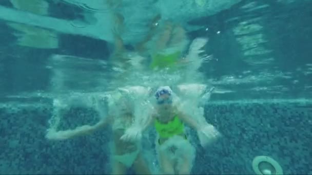 Duas crianças estão imersas na água da piscina. Movimento lento — Vídeo de Stock