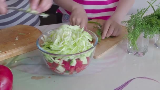 Подготовка овощного салата. Руки бабушки и ребенка режут овощи. 4K — стоковое видео