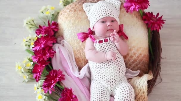 Beau bébé se trouve dans un panier avec des fleurs — Video