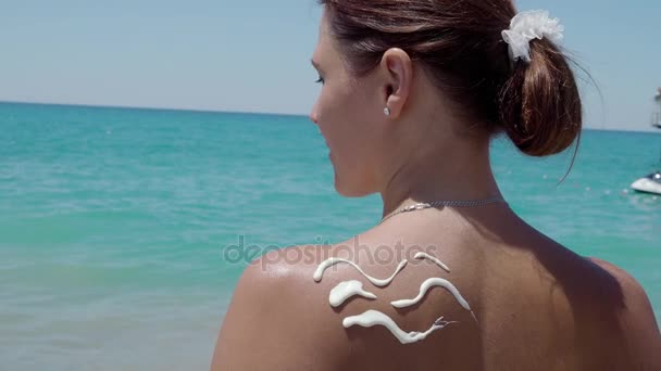 Mujer con crema solar en la playa en forma de ola. 4K — Vídeos de Stock