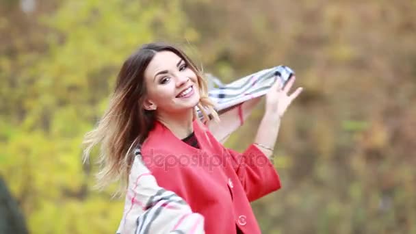 Belle fille joyeuse qui s'amuse à marcher dans le parc d'automne tourbillonnant — Video