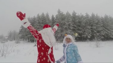 Noel Baba ve Noel topları ile torunu kış ormanda dans. Slow Motion Picture