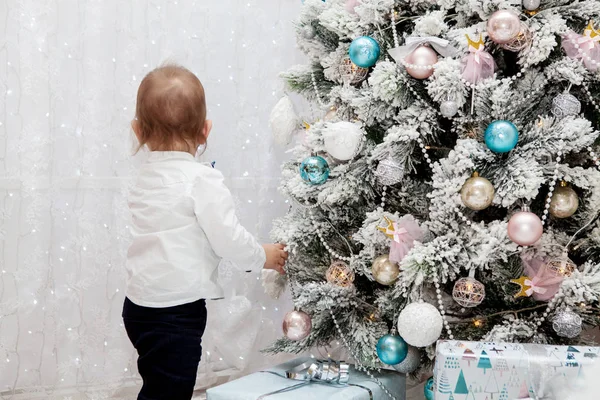 Uma criança pequena em um interior de Ano Novo. Ano Novo e Natal — Fotografia de Stock