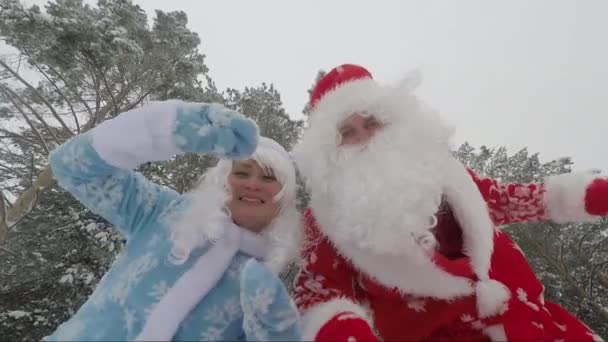 Père Noël avec sa petite-fille Snow Maiden danse joyeusement dans la forêt d'hiver dans la nouvelle année . — Video