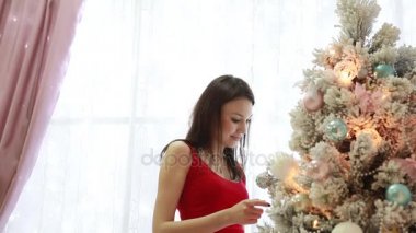 Güzel kız yakın bir Noel ağacı iç dekorasyon