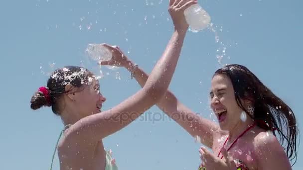 Jonge moeder en dochter tiener plezier beregening water op zichzelf uit een fles — Stockvideo