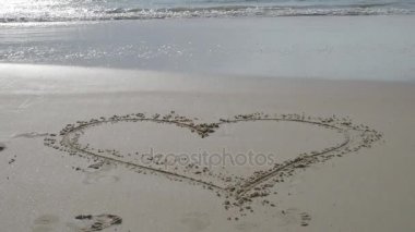 Kalp vona ile Hint Okyanusu kum üzerinde. 4k