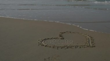 arka plan dalga ile kalp bir kum Beach üzerinde. 4k