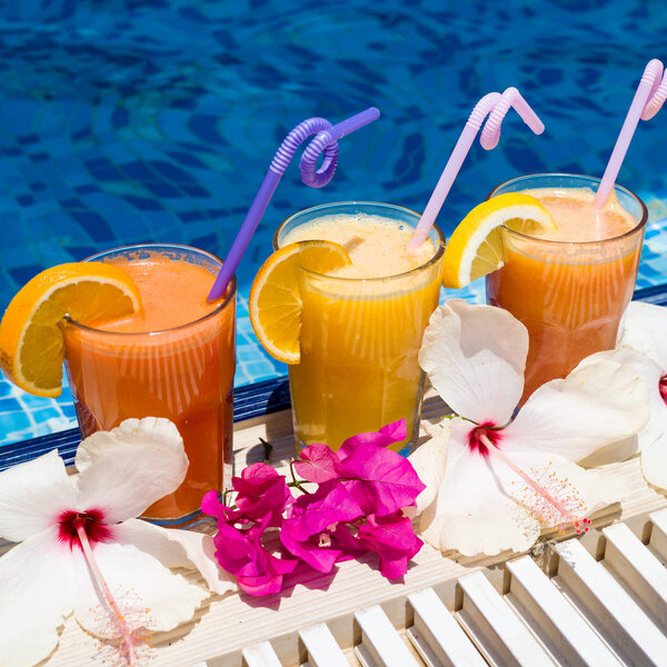Natural fresh squeezed juice with pieces of fruit in the resort by the pool
