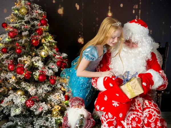 Noel Baba ve kız yeni yıl ağacının yanında bir hediyeyle — Stok fotoğraf