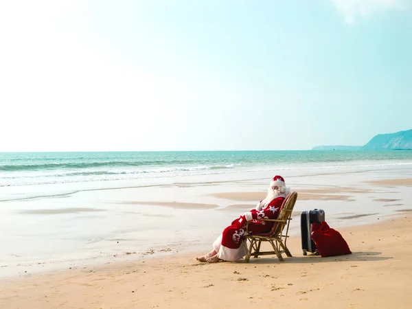 Babbo Natale viaggia con una valigia in mare — Foto Stock