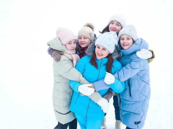 Mladá krásná matka s dcerami stojí objímající na zimní den na procházce — Stock fotografie